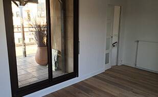 Travaux de Rénovation d'un appartement avec porte vitrée coulissante et parquet massif